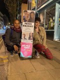 Leann O'Kasi & Sarah J. Lewis next to a lamppost banner, St James's St, Brighton